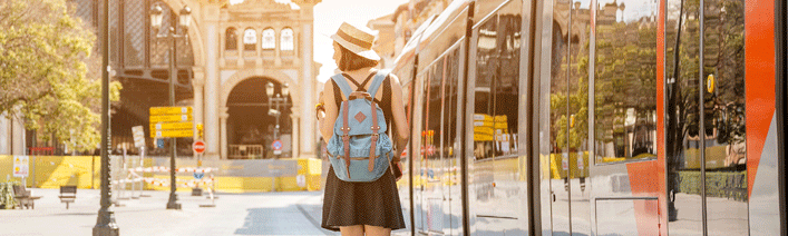 Mädchen mit Rucksack wartet auf Straßenbahn in Zaragoza 
